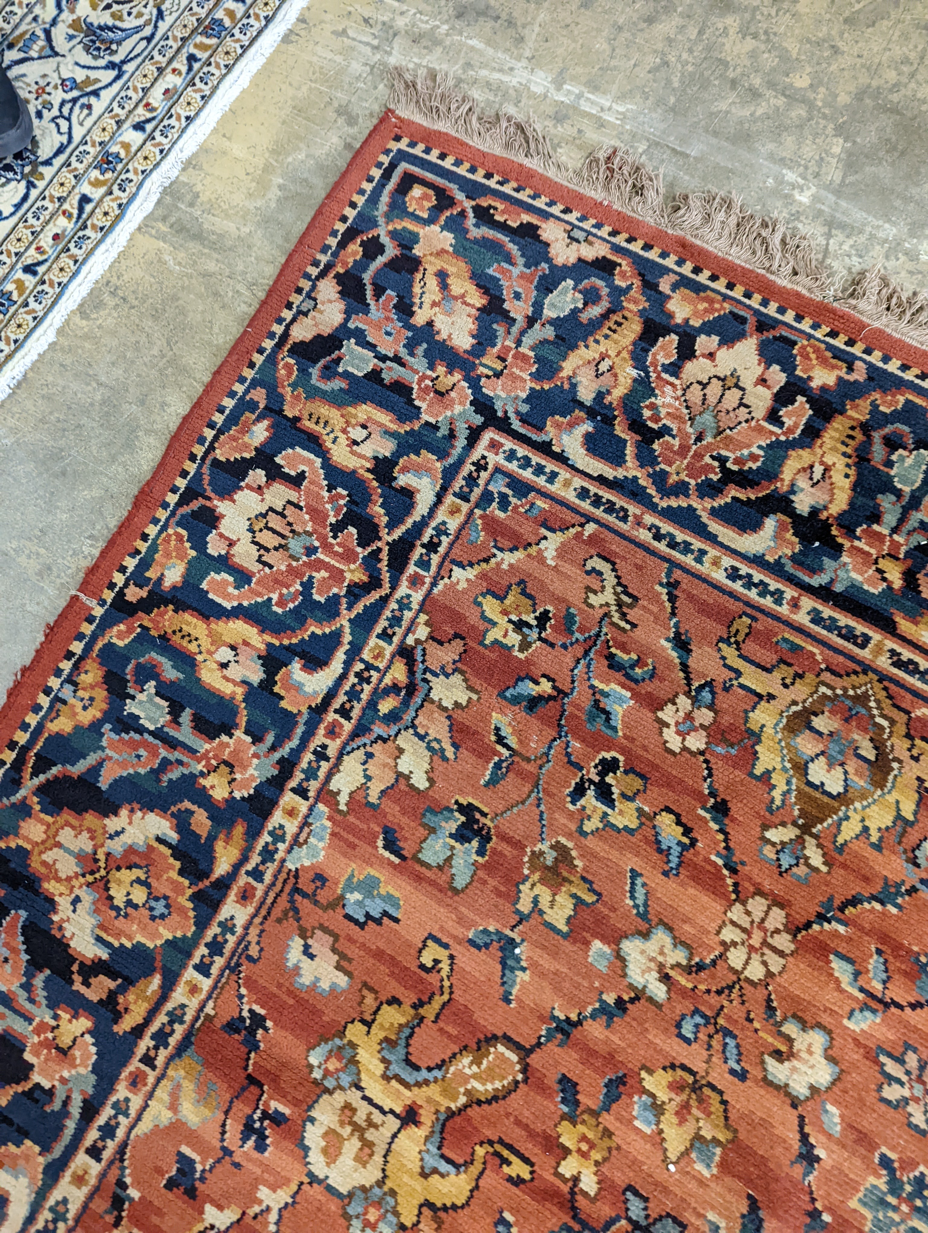 A Persian style machined brick red ground carpet (severely worn), 392 x 286cm